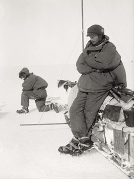 Fotografia em preto e branco mostrando dois exploradores em um ambiente de neve.