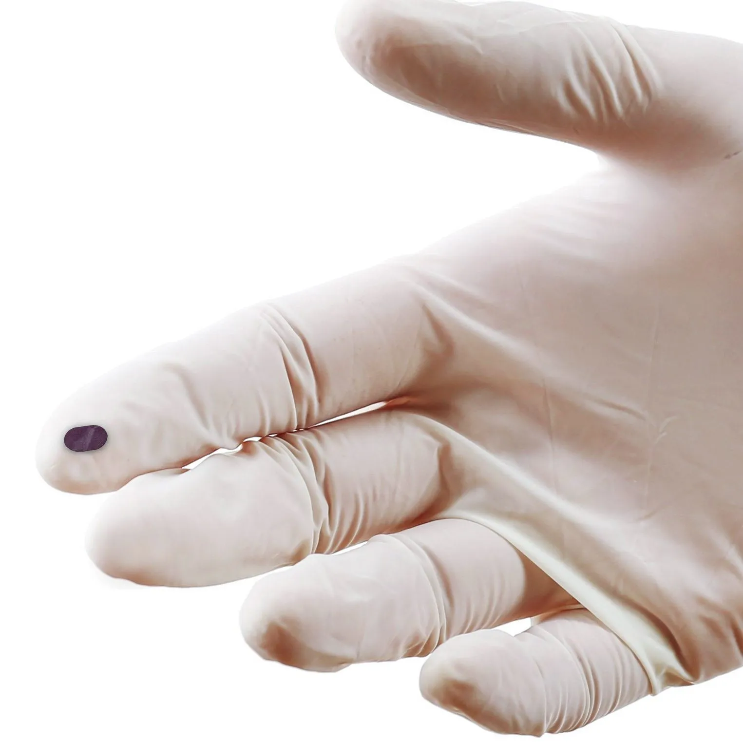 Uma mão usando uma luva cirúrgica de látex segura uma retina artificial, um pequeno implante flexível e de cor escura.